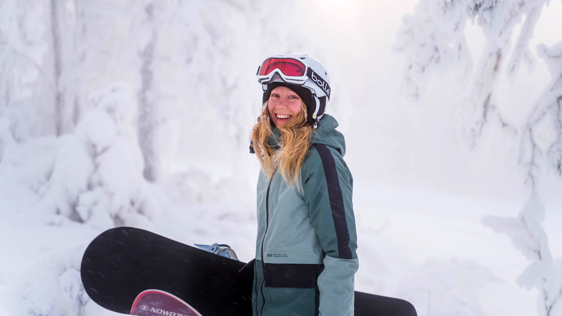 Laskettelu Kuopiossa ja Tahkolla. Nainen lumilaudan kanssa rinteessä.