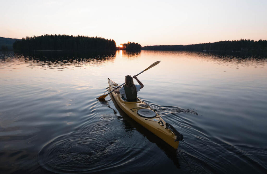 Nainen melomassa Tahkolla auringonlaskun aikaan